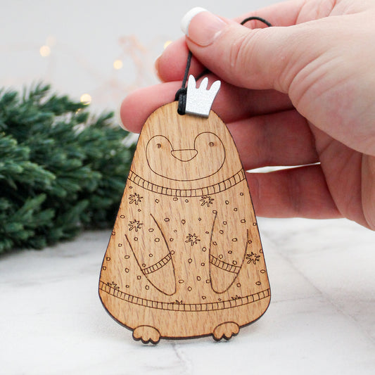 wooden penguin Christmas tree decoration in festive jumper and silver crown