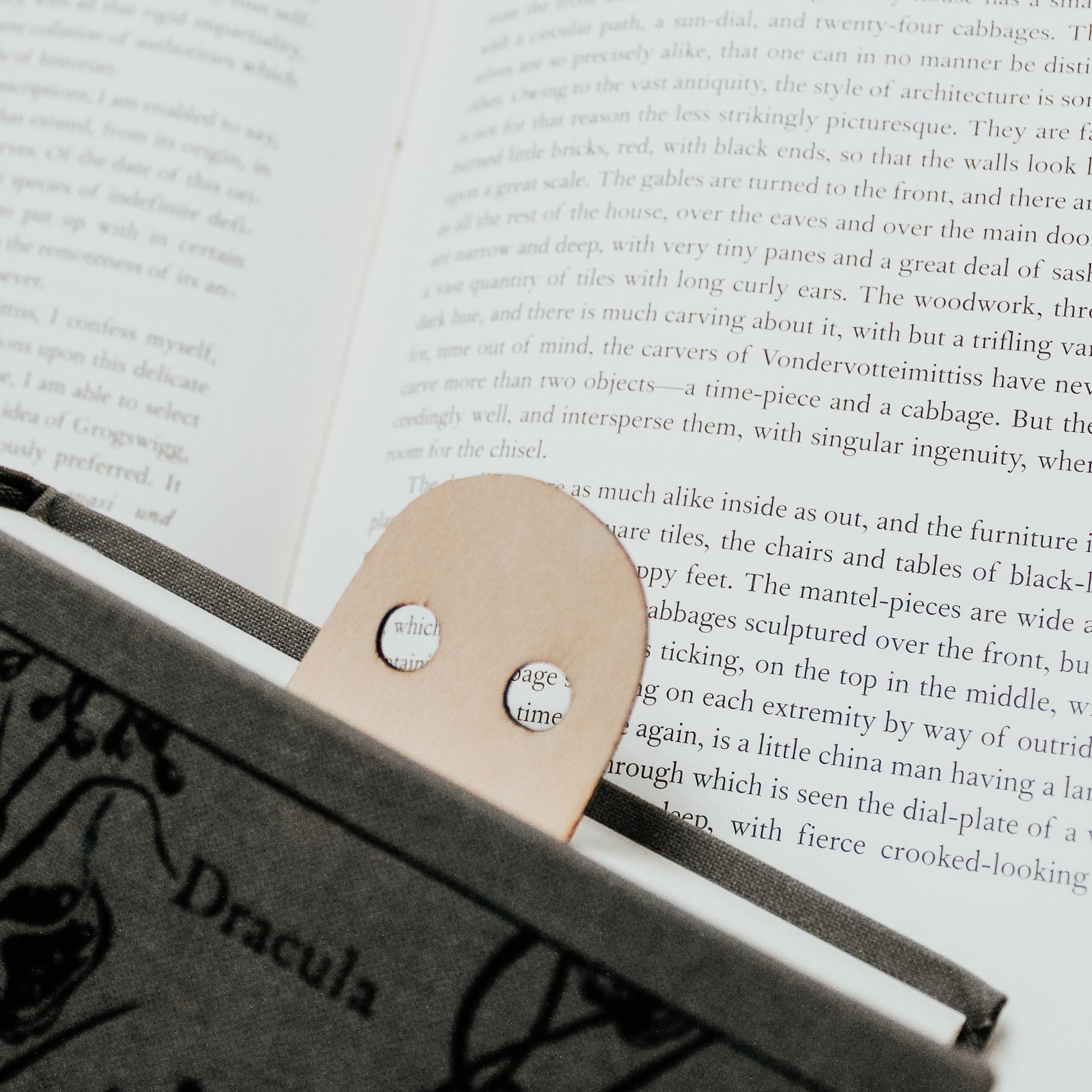 spooky wooden ghost bookmark peeking out of a book
