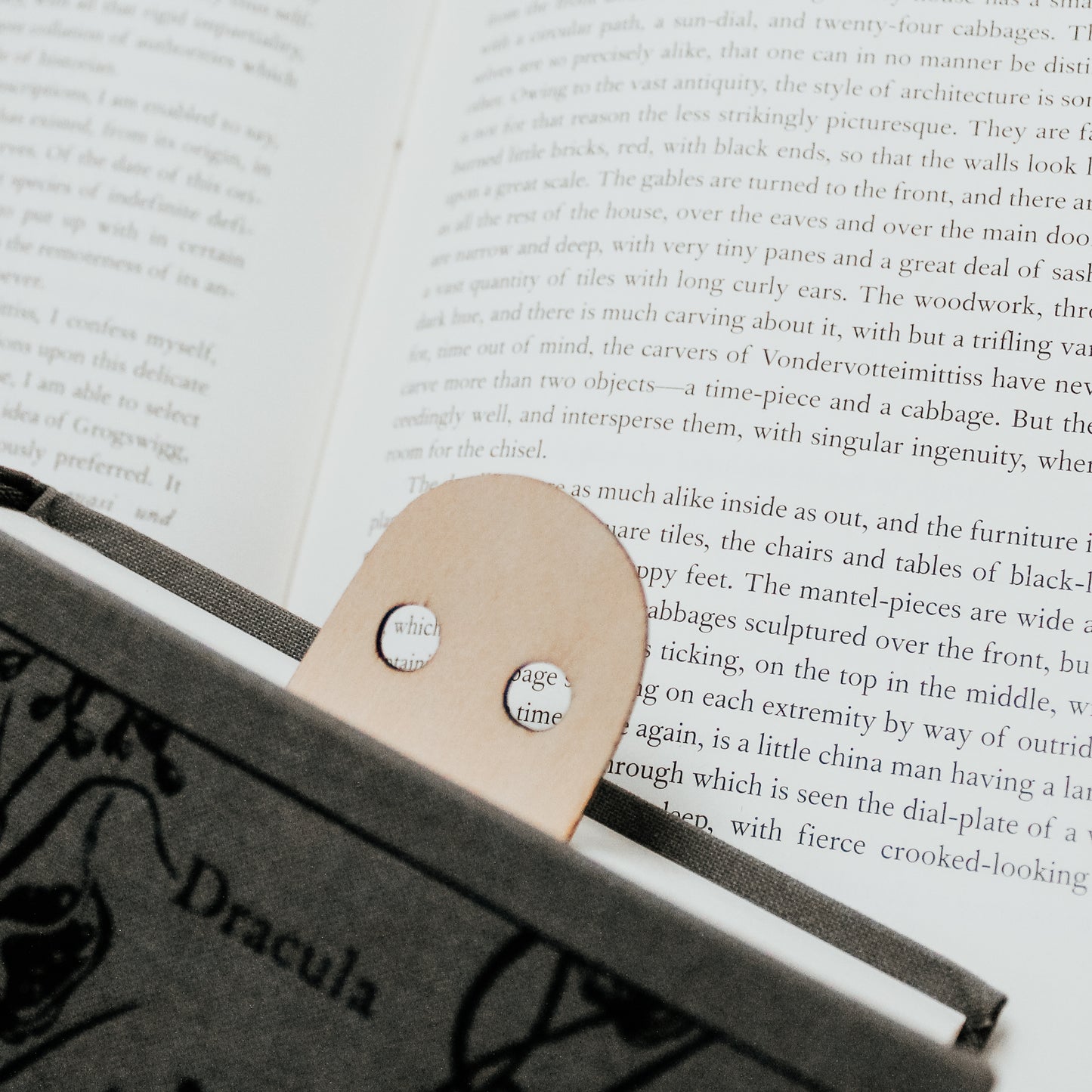 spooky wooden ghost bookmark peeking out of a book 