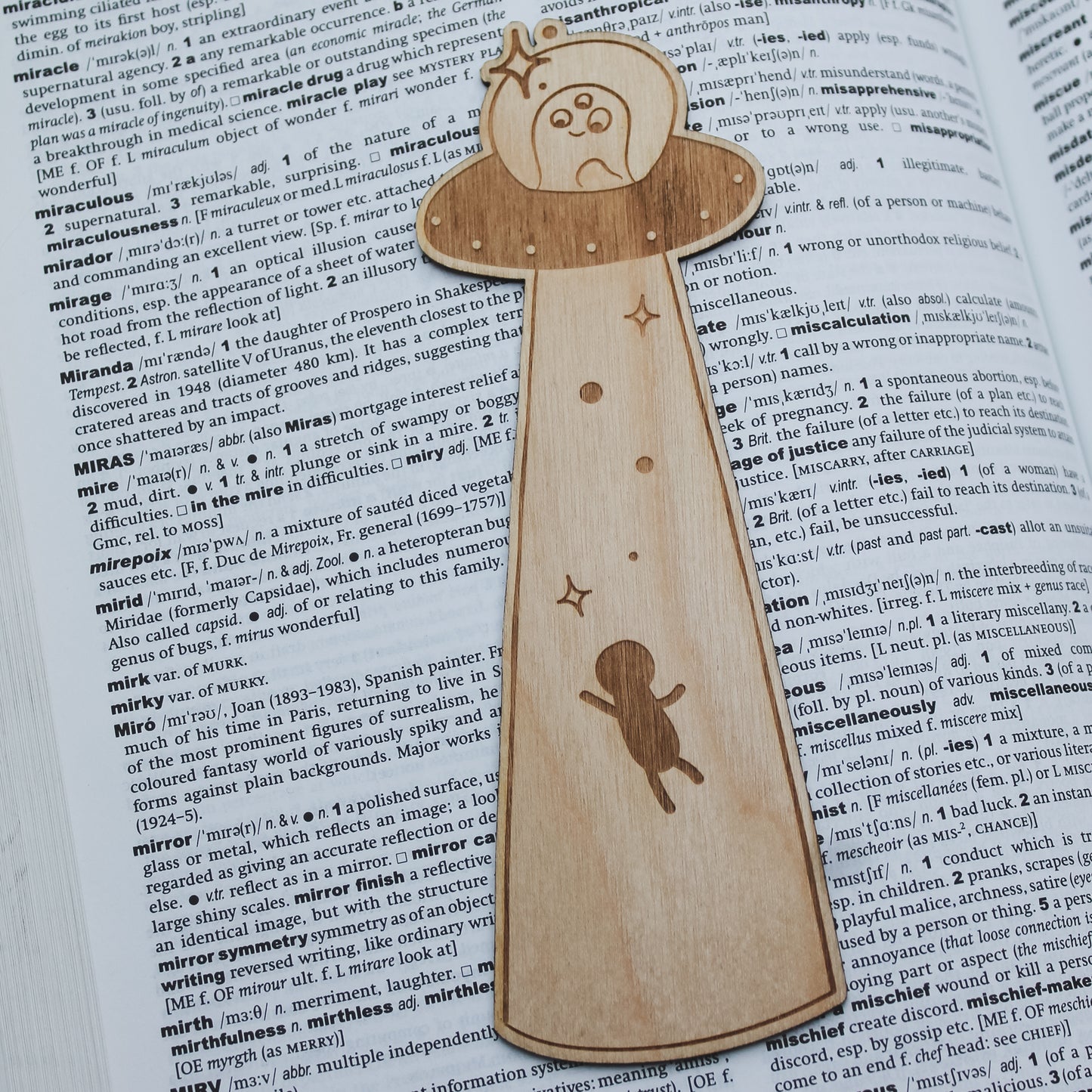 Wooden ufo bookmark, sitting on an open book