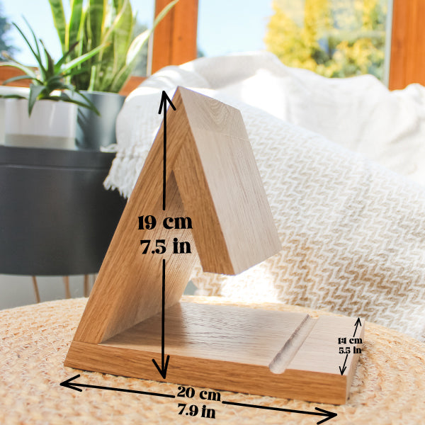 A triangular wooden display stand or shelf made of light natural wood, shown on a woven surface in a bright indoor setting. Black measurement arrows and text overlay indicate dimensions: 19 cm height, 20 cm base width, and 14 cm side depth.
