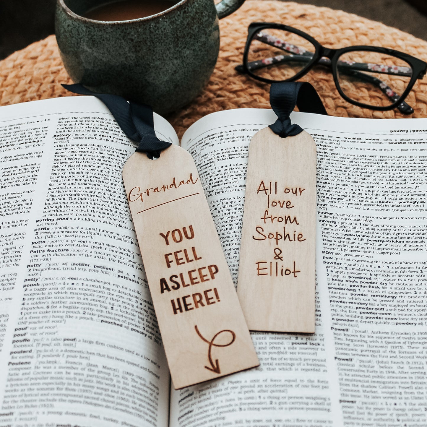Wooden bookmark engraved with a lighthearted message "Grandad you fell asleep here" with an arrow pointing down to the book. Adorned with a blue ribbon, it's a charming gift for grandfathers who enjoy getting lost in a good story. With the choice of personalisation on the reverse with your own message