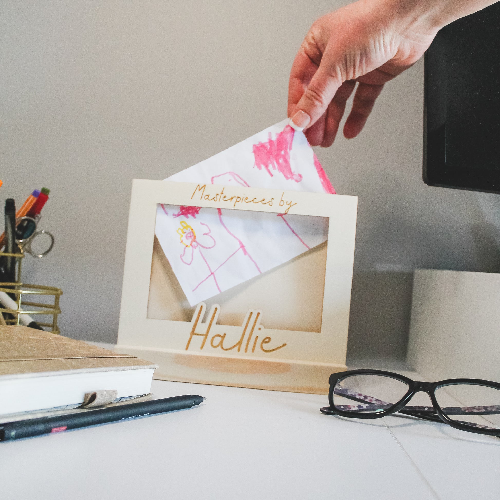 Handmade wooden kids' art display frame with a sturdy stand, perfect for holding and swapping children's artwork.