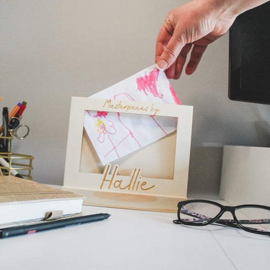 Handmade wooden kids' art display frame with a sturdy stand, perfect for holding and swapping children's artwork.
