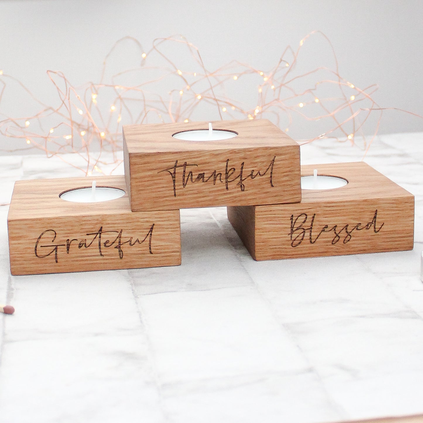 set of 3 solid oak tea light holders with the phrases grateful, thankful and blessed engraved on them