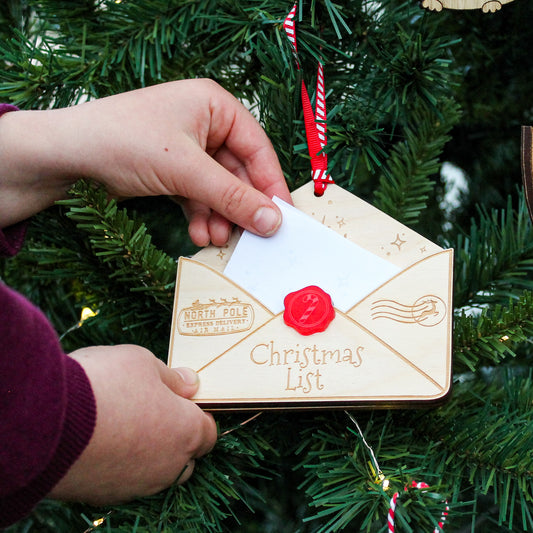 wooden envelope that is engraved with the words to santa and Christmas list. It is a envelope to hold your letter to santa and to hang on the christmas tree