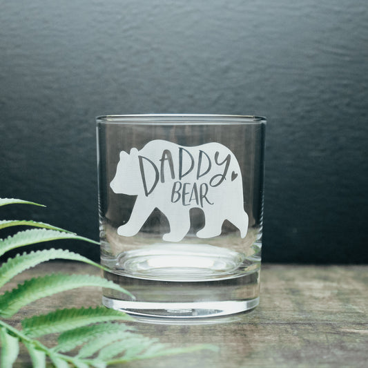glass tumbler with the words daddy bear in a bear design engraved onto the glass in white