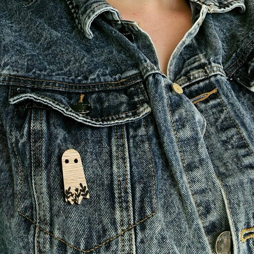 wooden ghost pin brooch affixed to a denim jacket