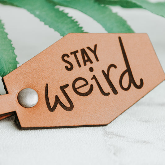 leather Keyring engraved with the words stay weird with real leather