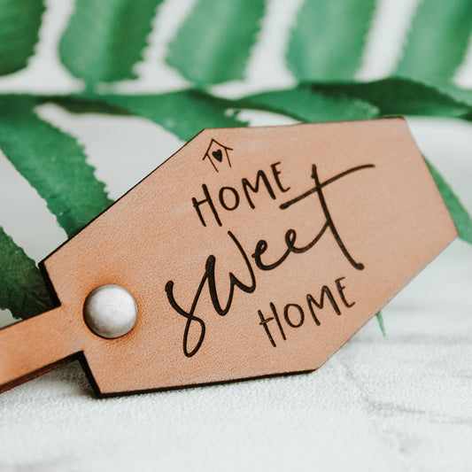 leather keyring showing an up close image of the text home sweet home on a whisky coloured leather