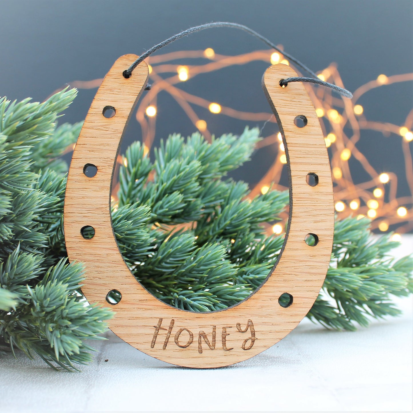 Wooden engraved horseshoe Christmas tree decoration with personalised name etched onto it.
