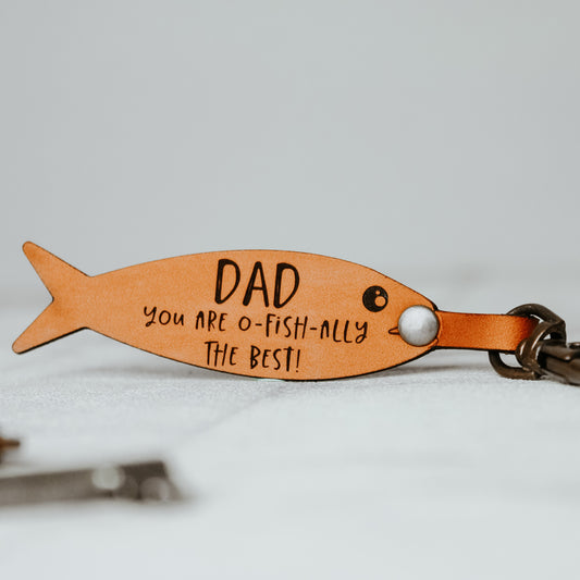 dad fishing keyring engraved on a fish shaped keyring in a whisky colour.