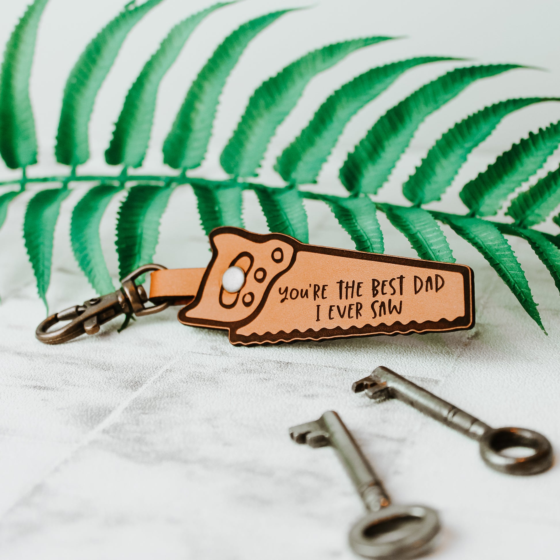 leather saw shaped keyring with, you're the best dad i ever saw, engraved onto it 