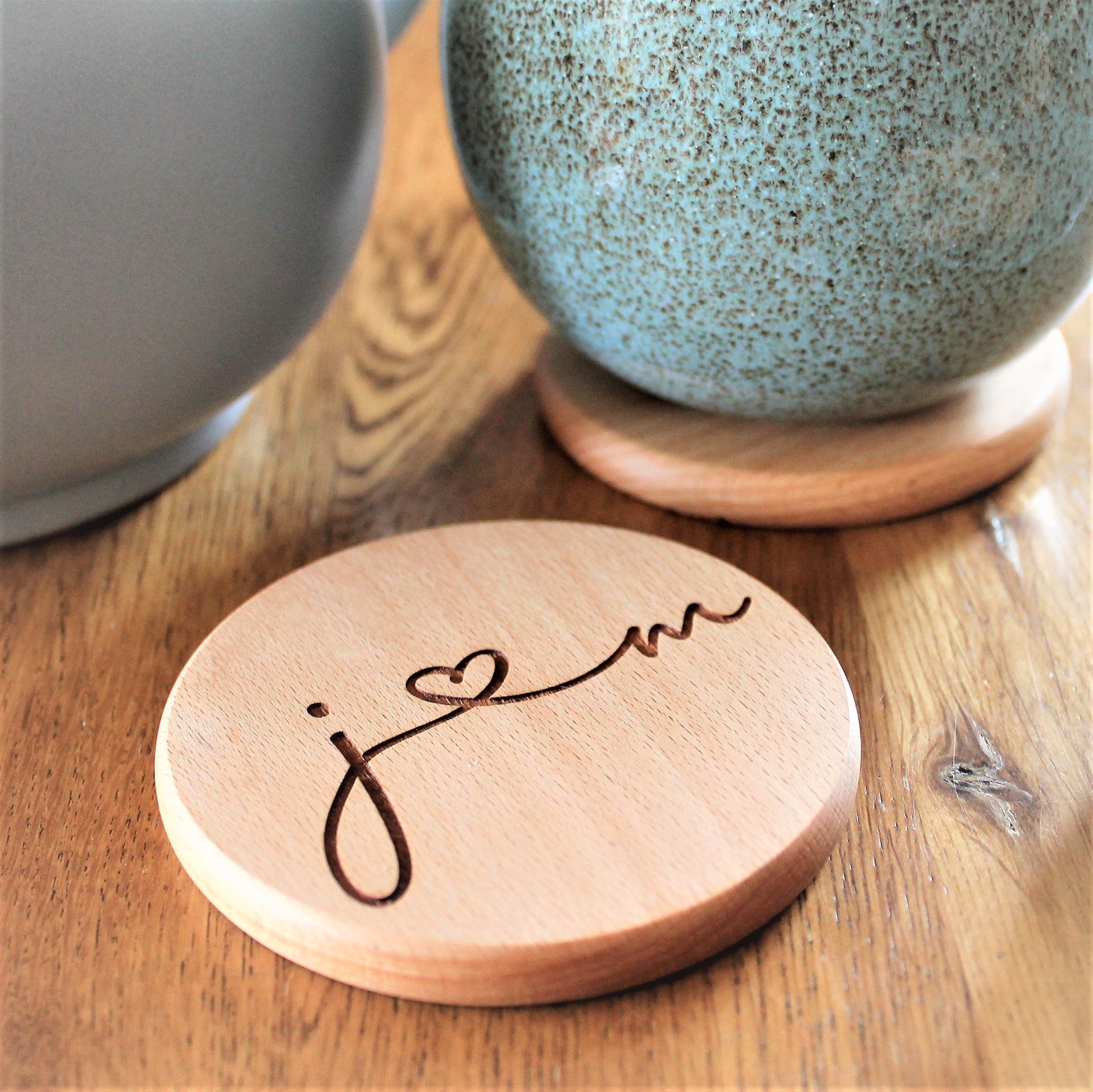 round wooden coaster engraved with couples initials