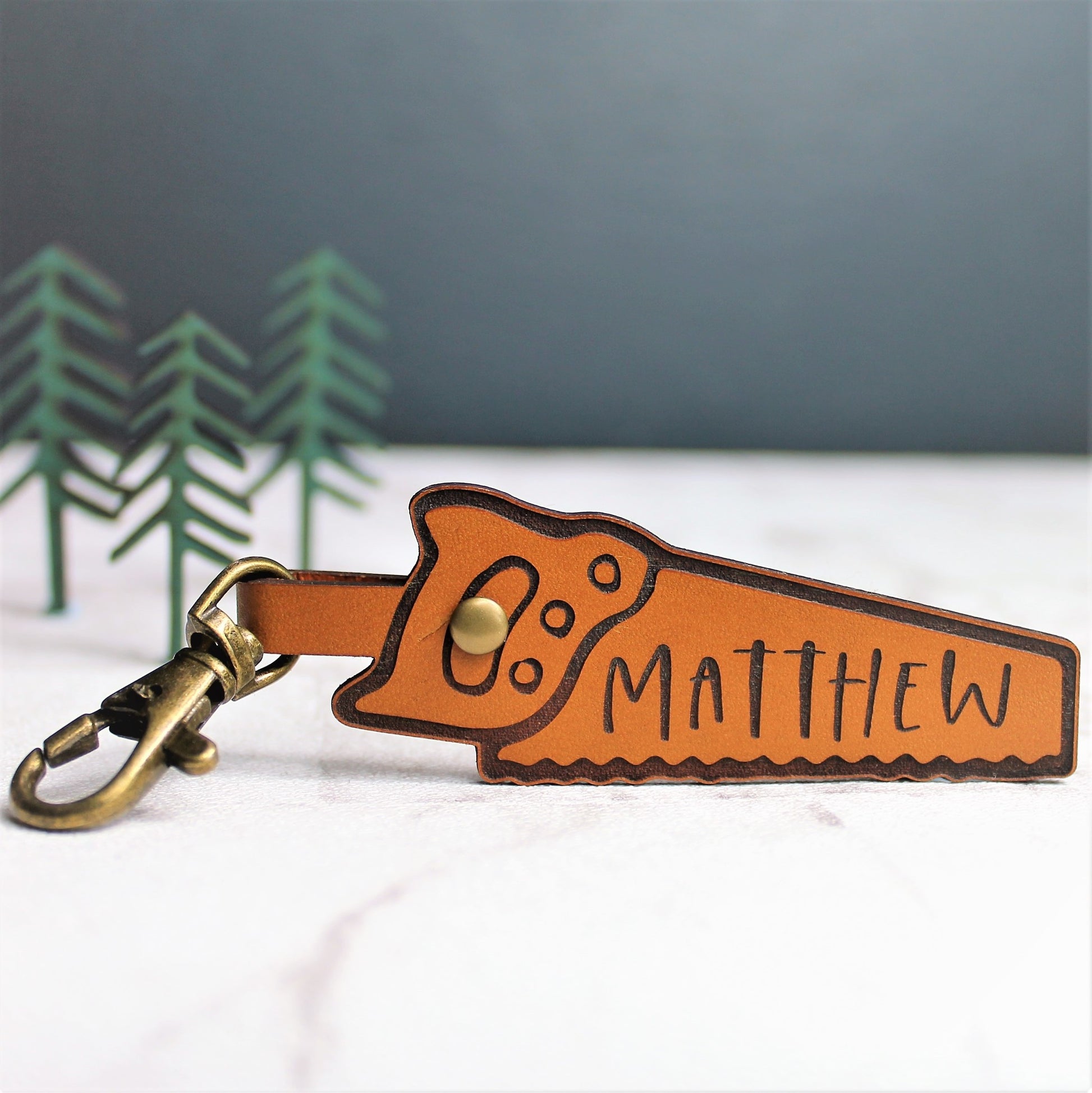 wood saw shaped leather keyring personalised with a name and brass clasp
