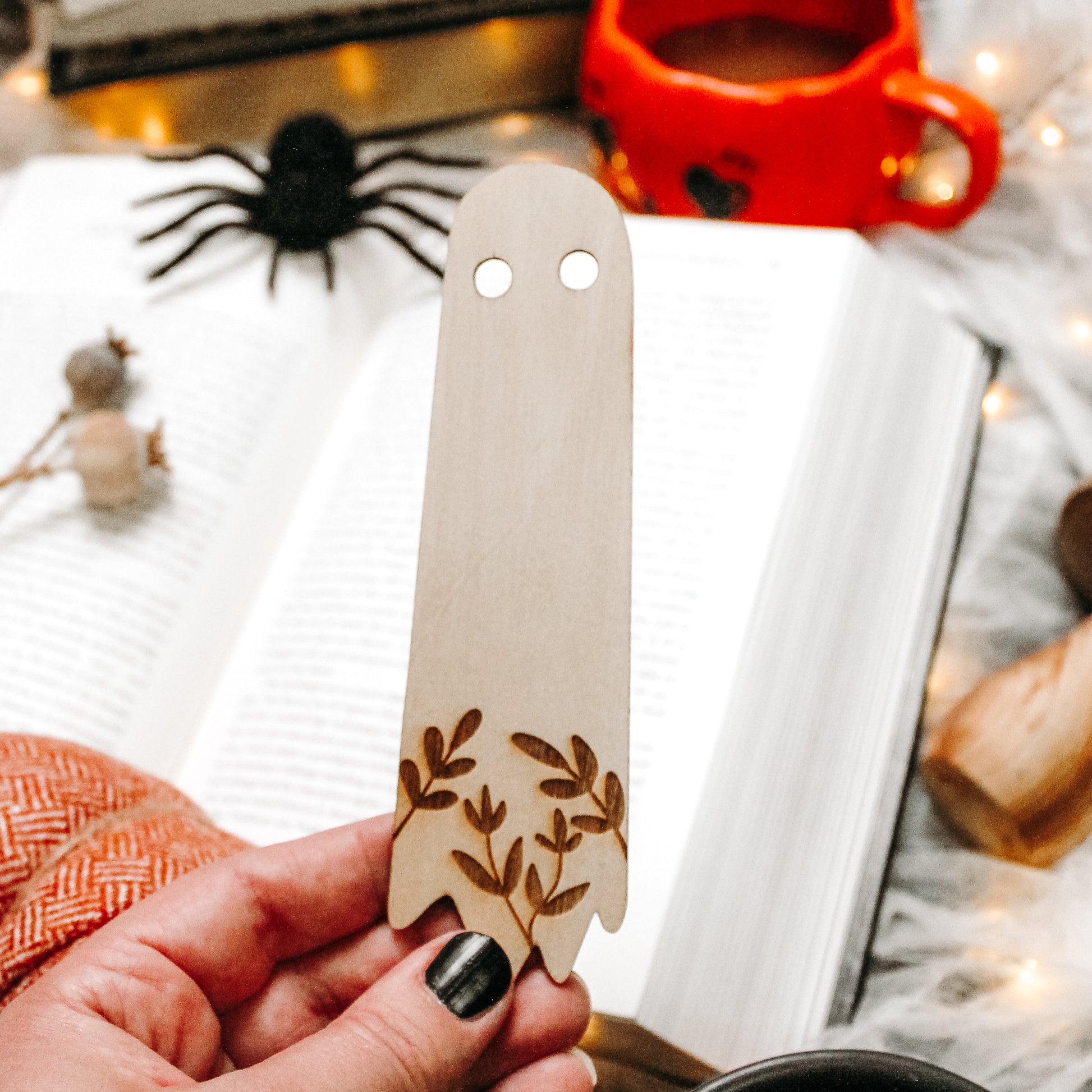 Ghost bookmark companion made from wood and has a botanical design engraved up it 