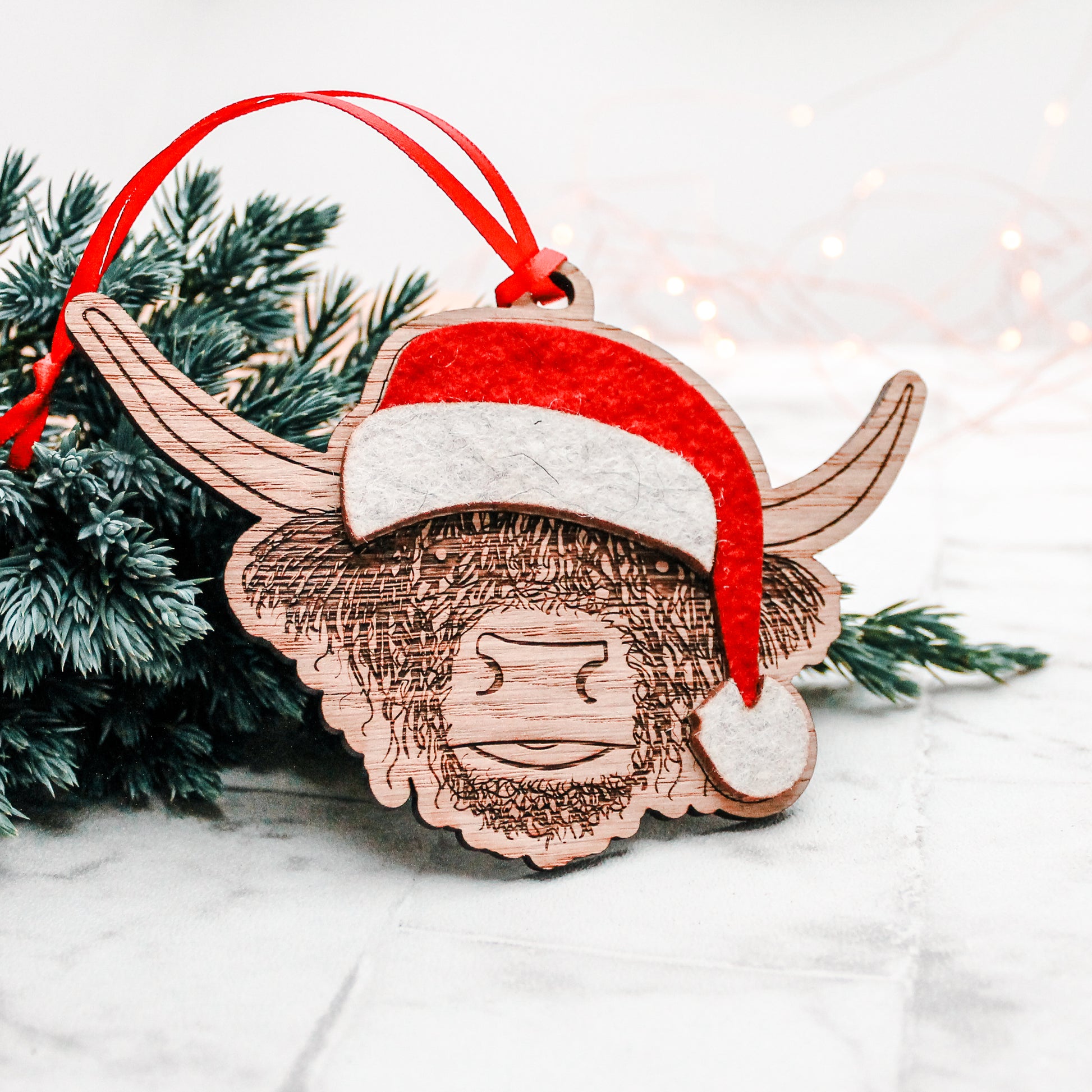 wooden Scottish highland cow Christmas tree decoration with felt Santa hat 