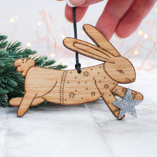 wooden rabbit Christmas tree decoration in winter jumper and holding a silver star