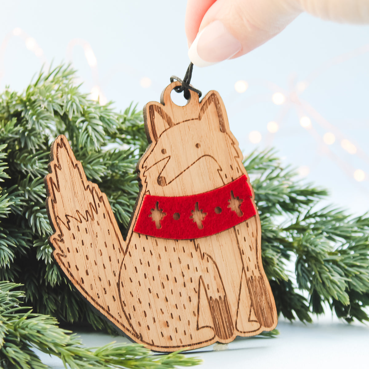 Wooden fox ornament with a red scarf on a Christmas tree