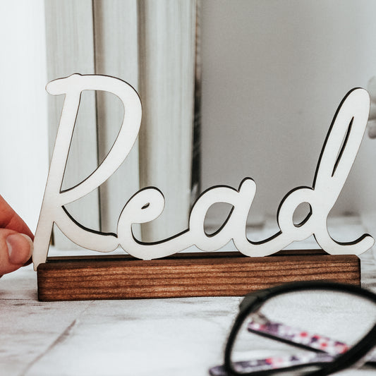wooden read sign with cut out calligraphic word, perfect for a book nook or bookshelf decor