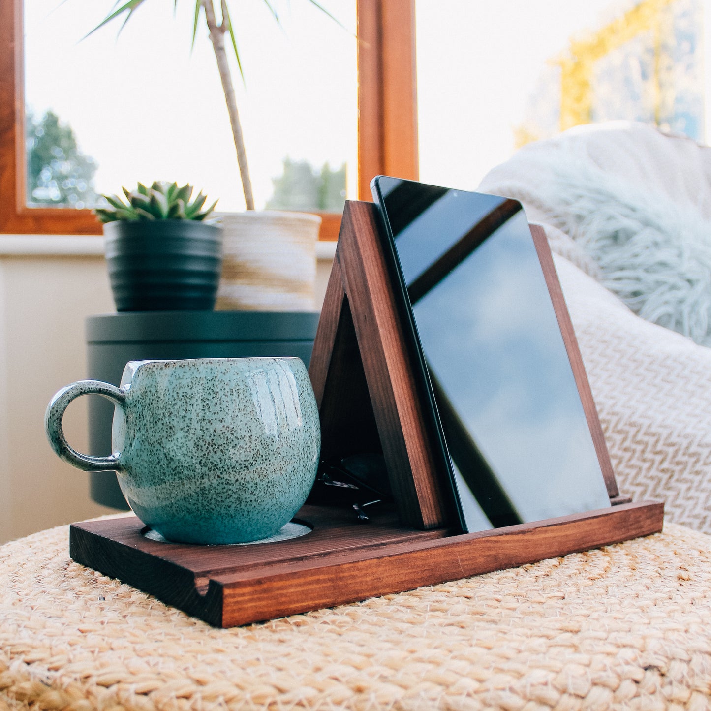 Close-up of a dark wooden book valet showcasing its functionality with an tablet or kindle device resting against it and a mug of tea