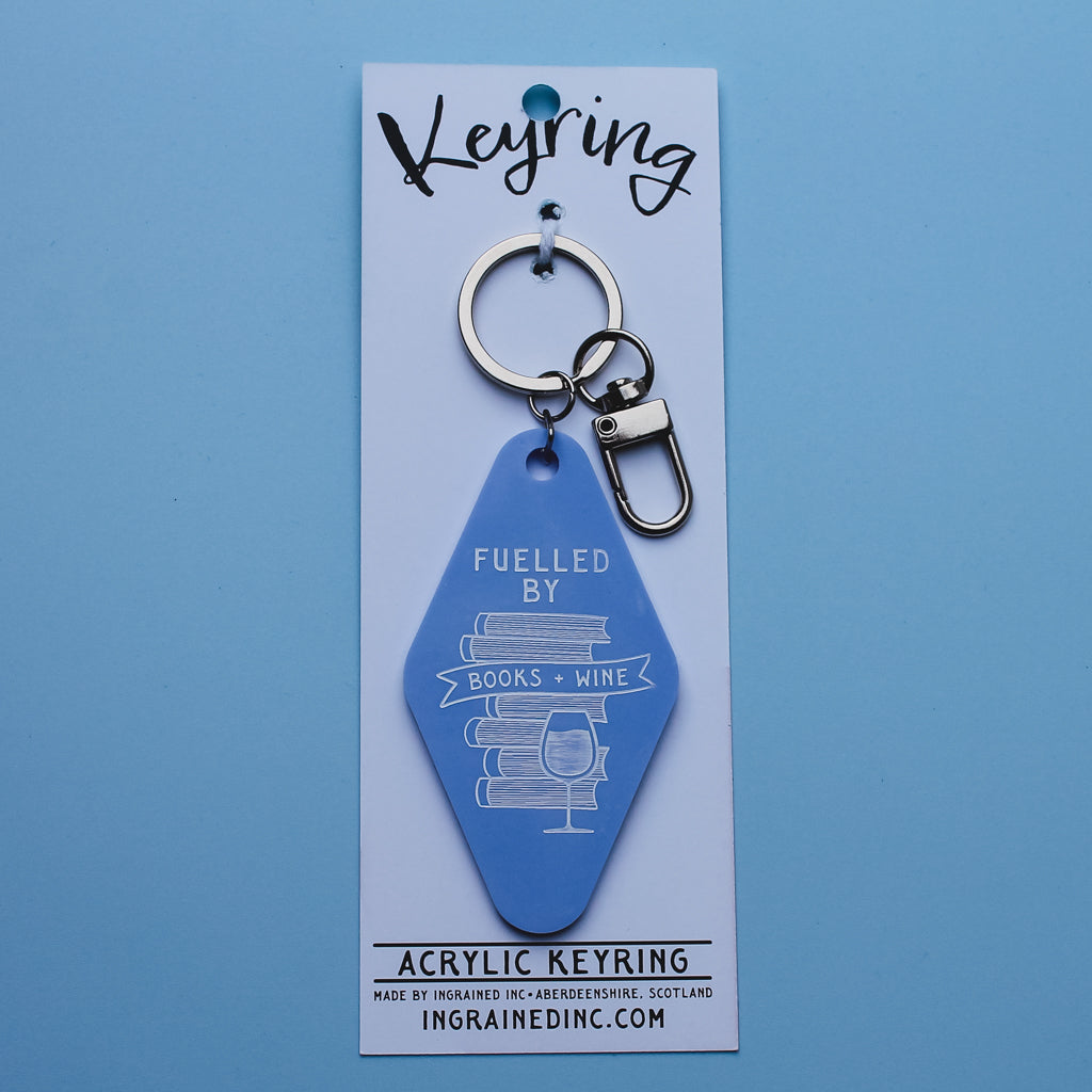 Blue motel style keyring with 'Fuelled by Books & Wine' text on a blue background