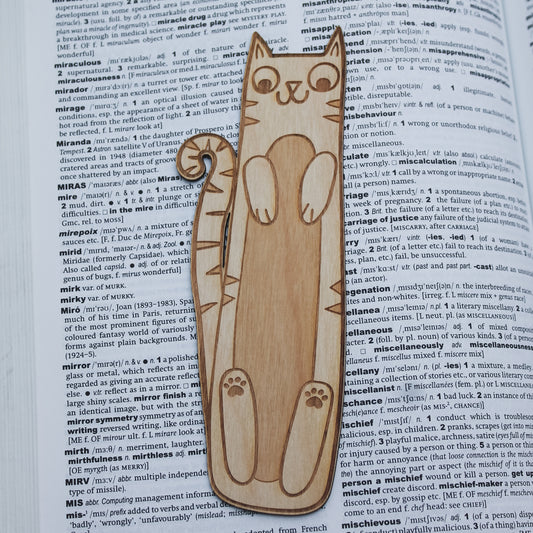 Cat-shaped wooden bookmark on an open book