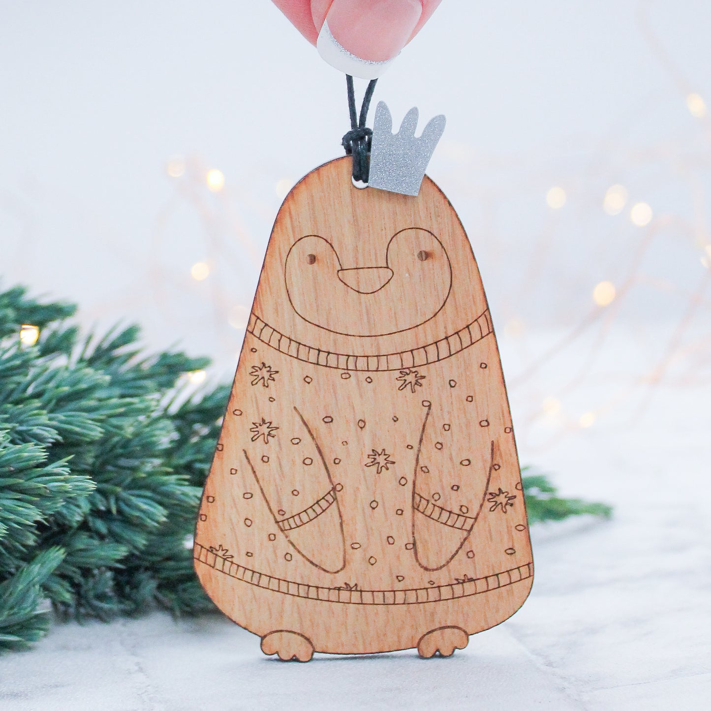 wooden penguin Christmas tree decoration in Christmas jumper and silver crown  