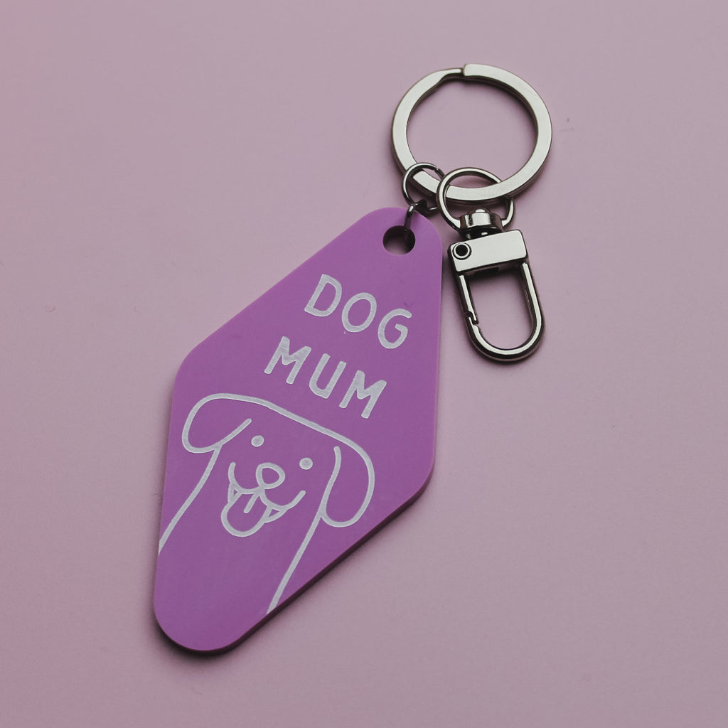 Pink Motel Style keychain tag with 'DOG MUM' text and dog illustration on a pink background