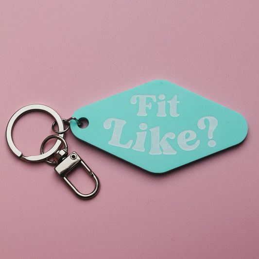 Turquoise motel style keyring tag with 'Fit Like?' text on a pink background