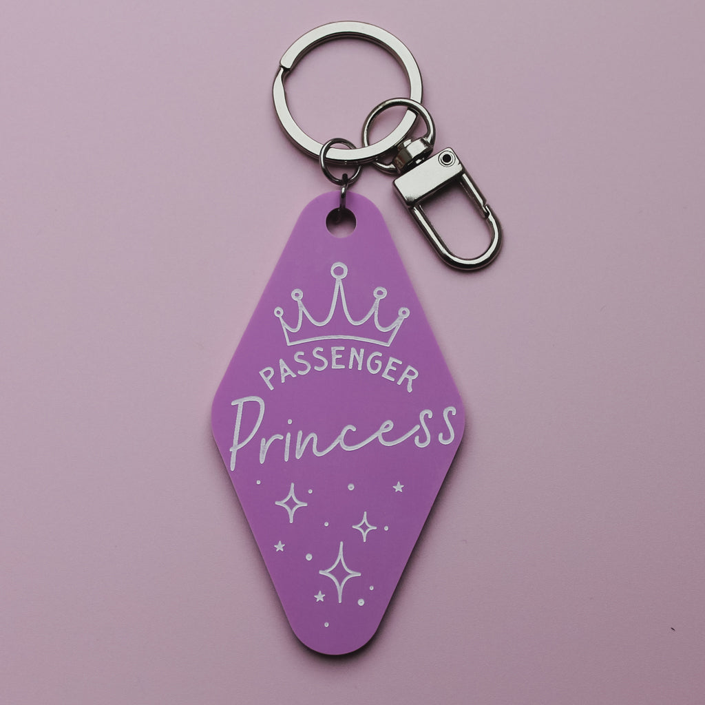 Pink Motel style keychain with 'Passenger Princess' text and crown design on a pink background