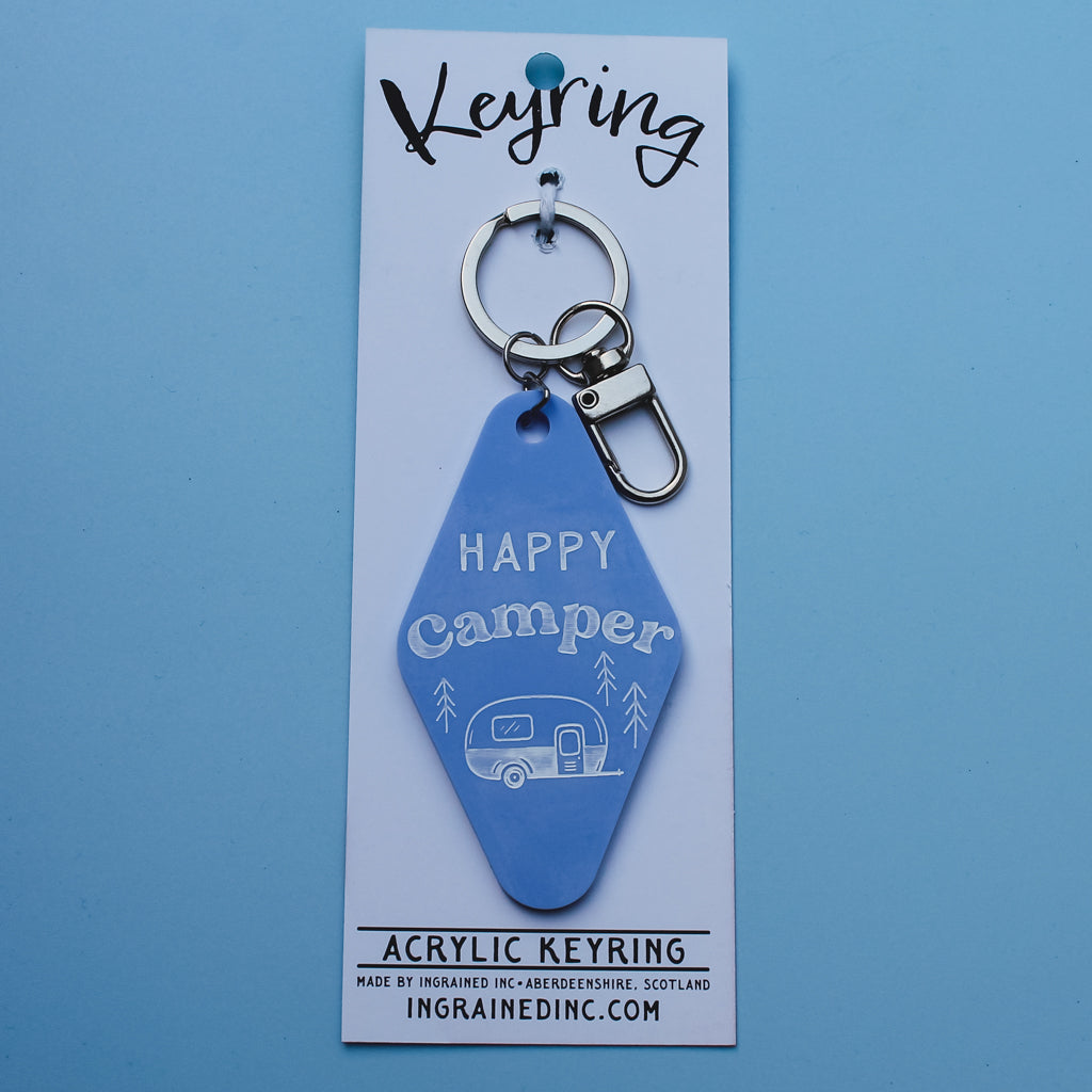 Blue acrylic motel style keyring with 'Happy Camper' design on a blue card
