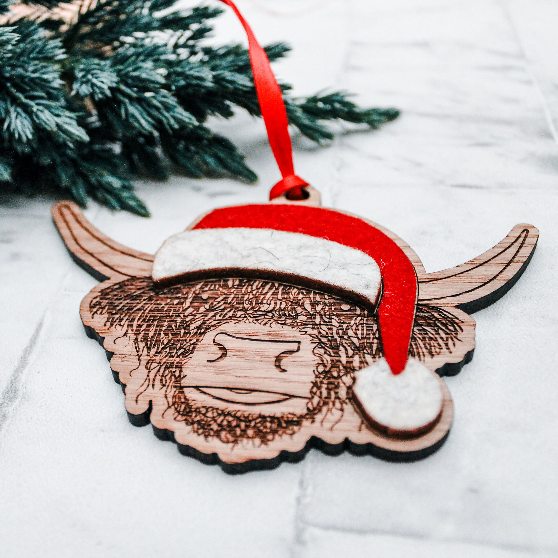 wooden Scottish highland cow Christmas tree decoration with felt Santa hat