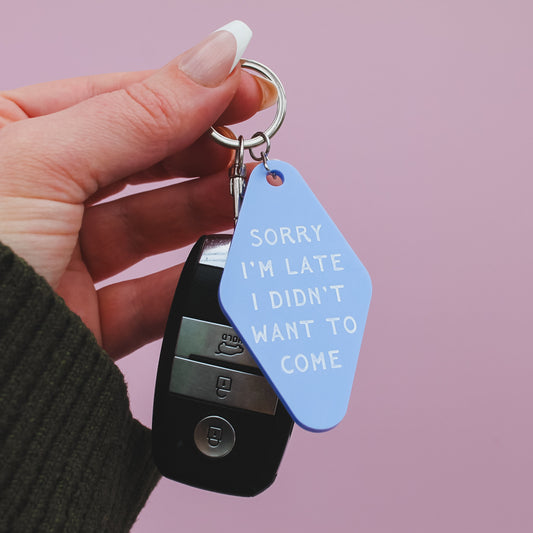 Motel style Keychain with a blue tag reading 'Sorry I'm late, I didn't want to come' against a pink background
