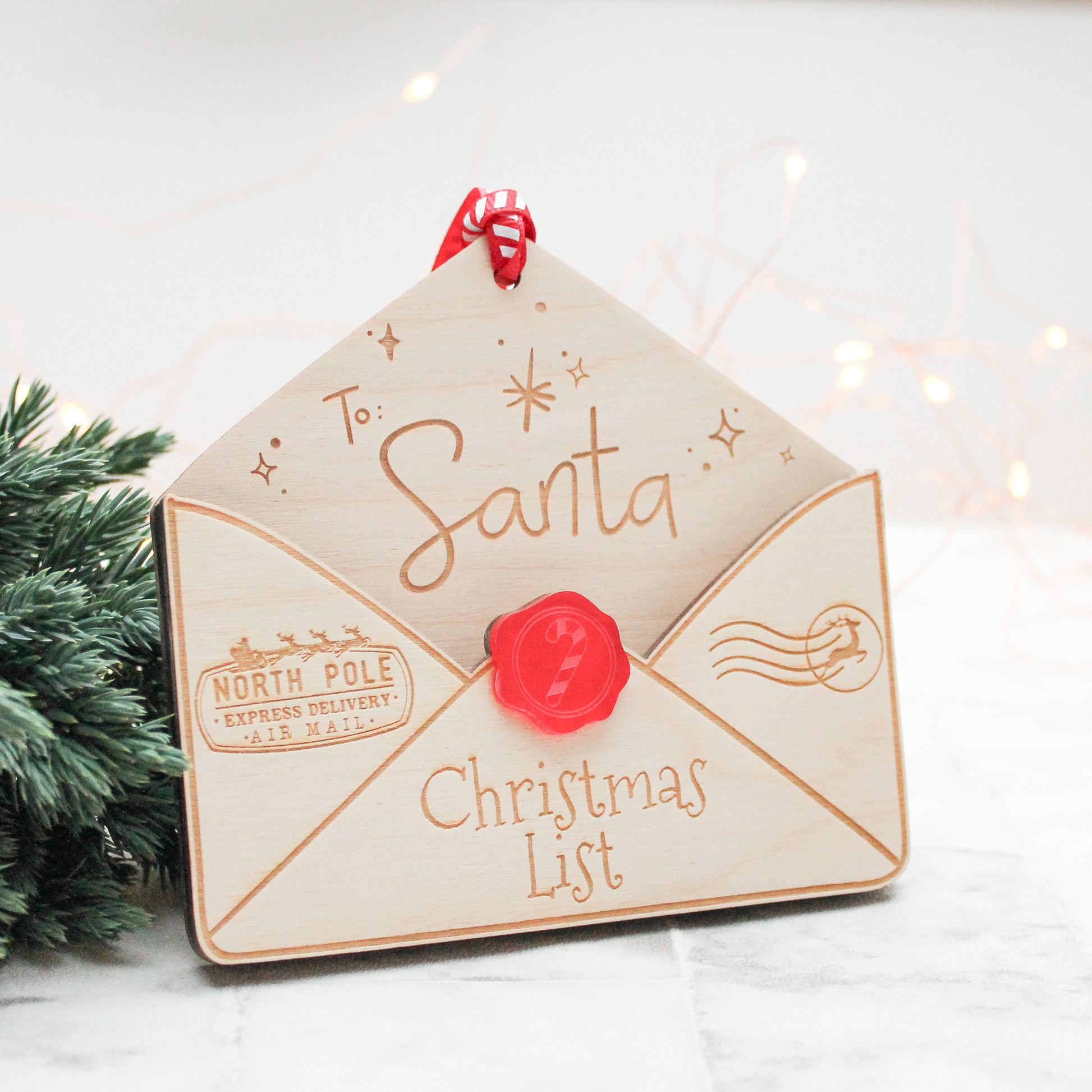wooden envelope that is engraved with the words to santa and Christmas list. It is a envelope to hold your letter to santa and to hang on the christmas tree