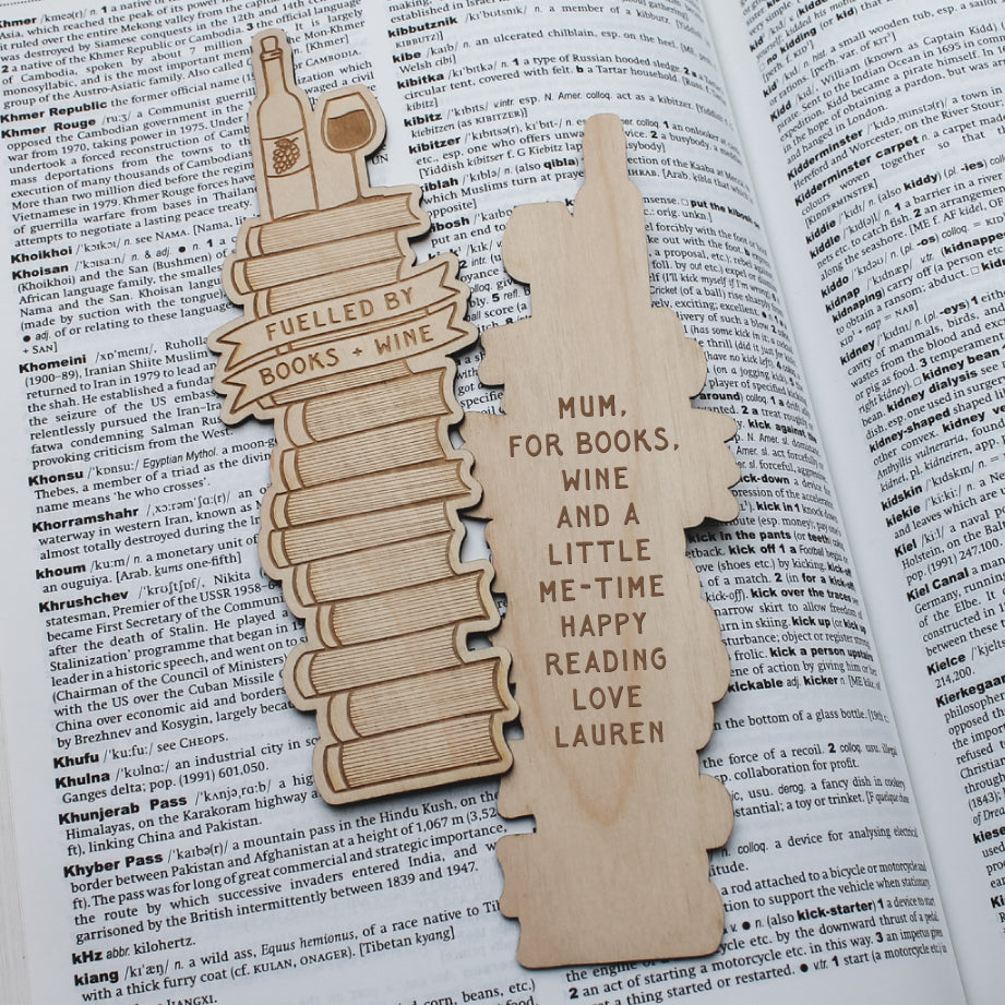 Wooden wine design bookmark with personalized text laying on an open book