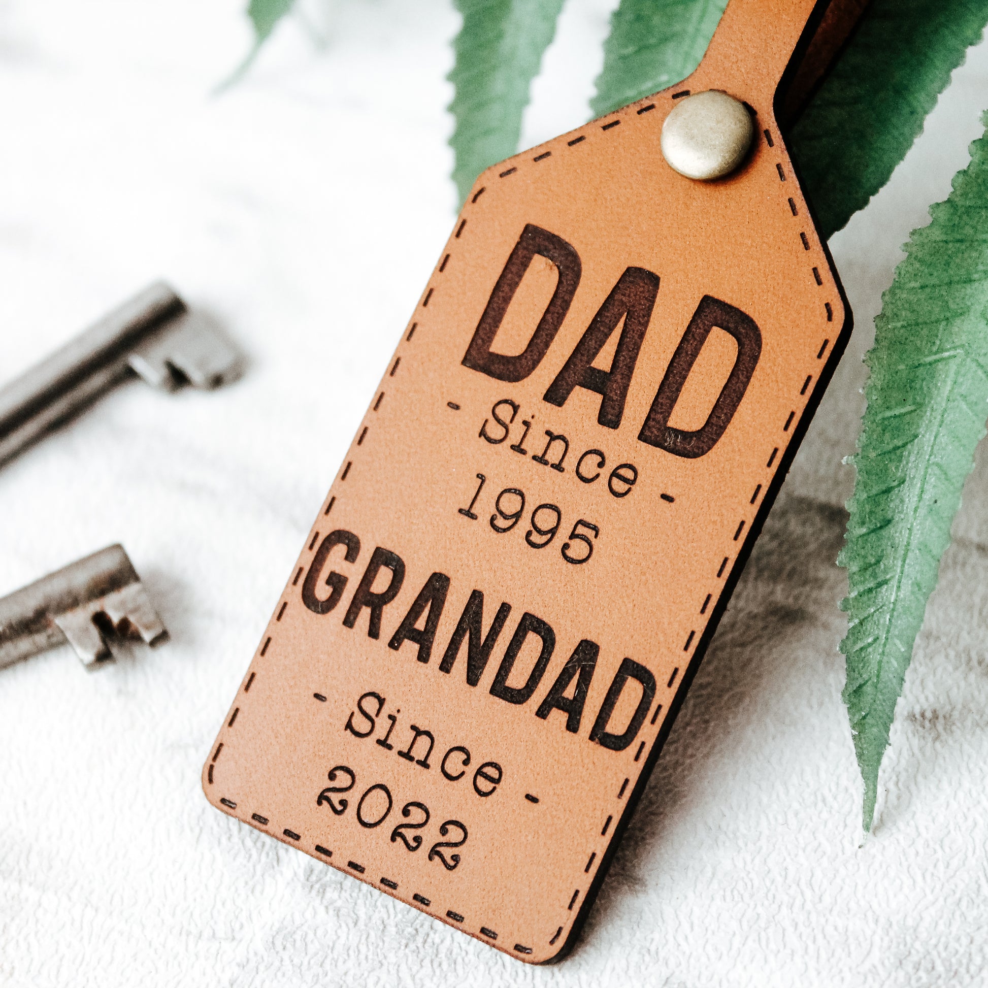 personalised leather keyring for grandad engraved with the text dad since 1995 and grandad since 2022, can be personalised with you own years and names 
