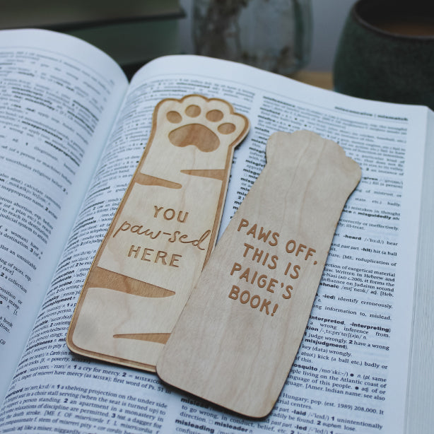 Wooden paw bookmark with the reverse of the bookmark showing personalised text and the engraving style used. If picking the personalisation option 