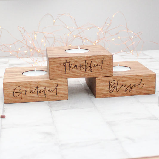 set of 3 solid oak tea light holders with the phrases grateful, thankful and blessed engraved on them 