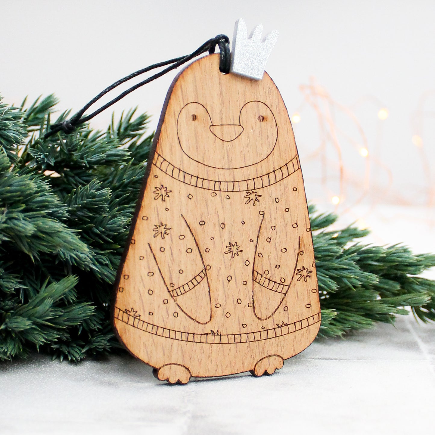 wooden king penguin Christmas tree decoration in Christmas jumper and silver crown 