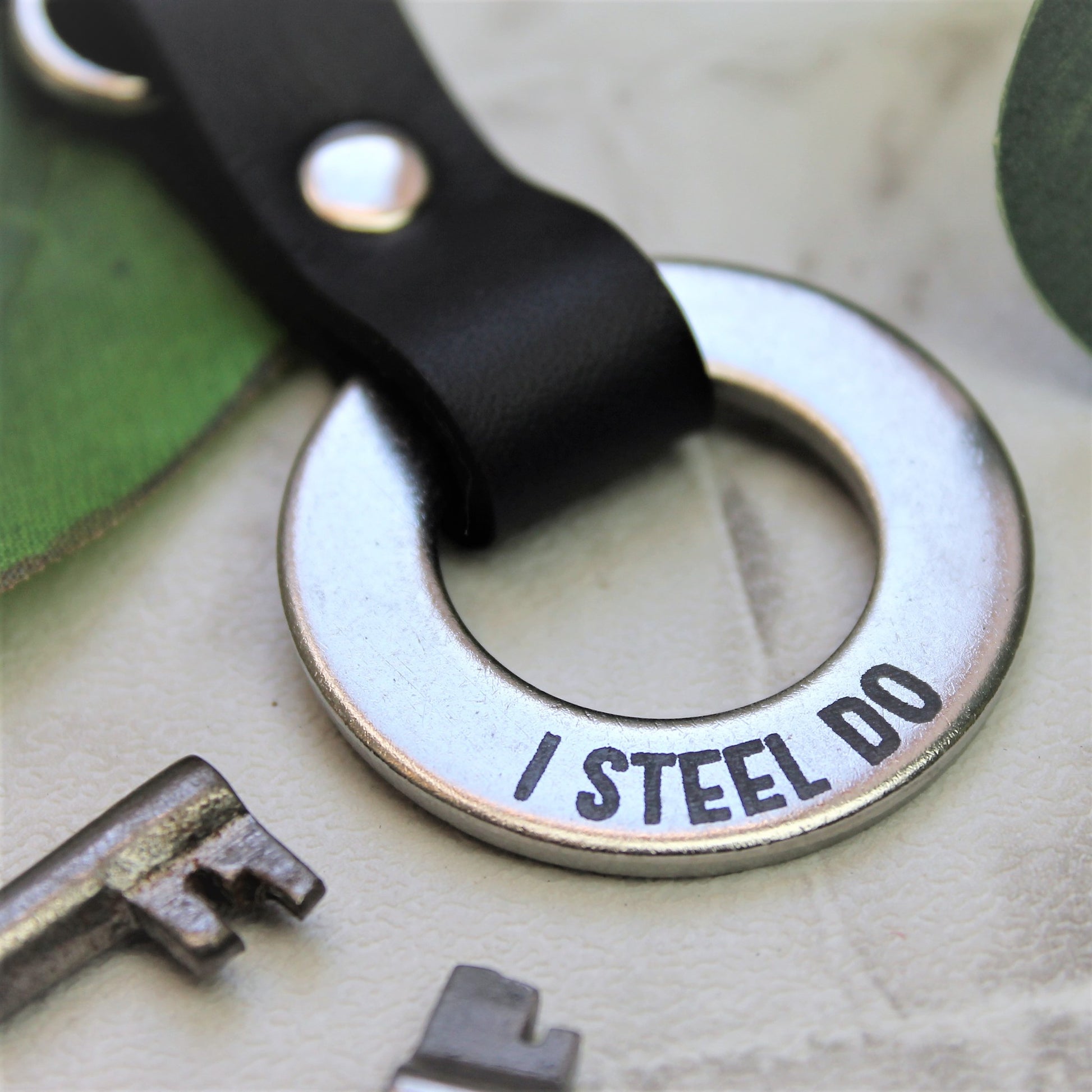 Metal stamped silver steel anniversary keyring with black leather attachments