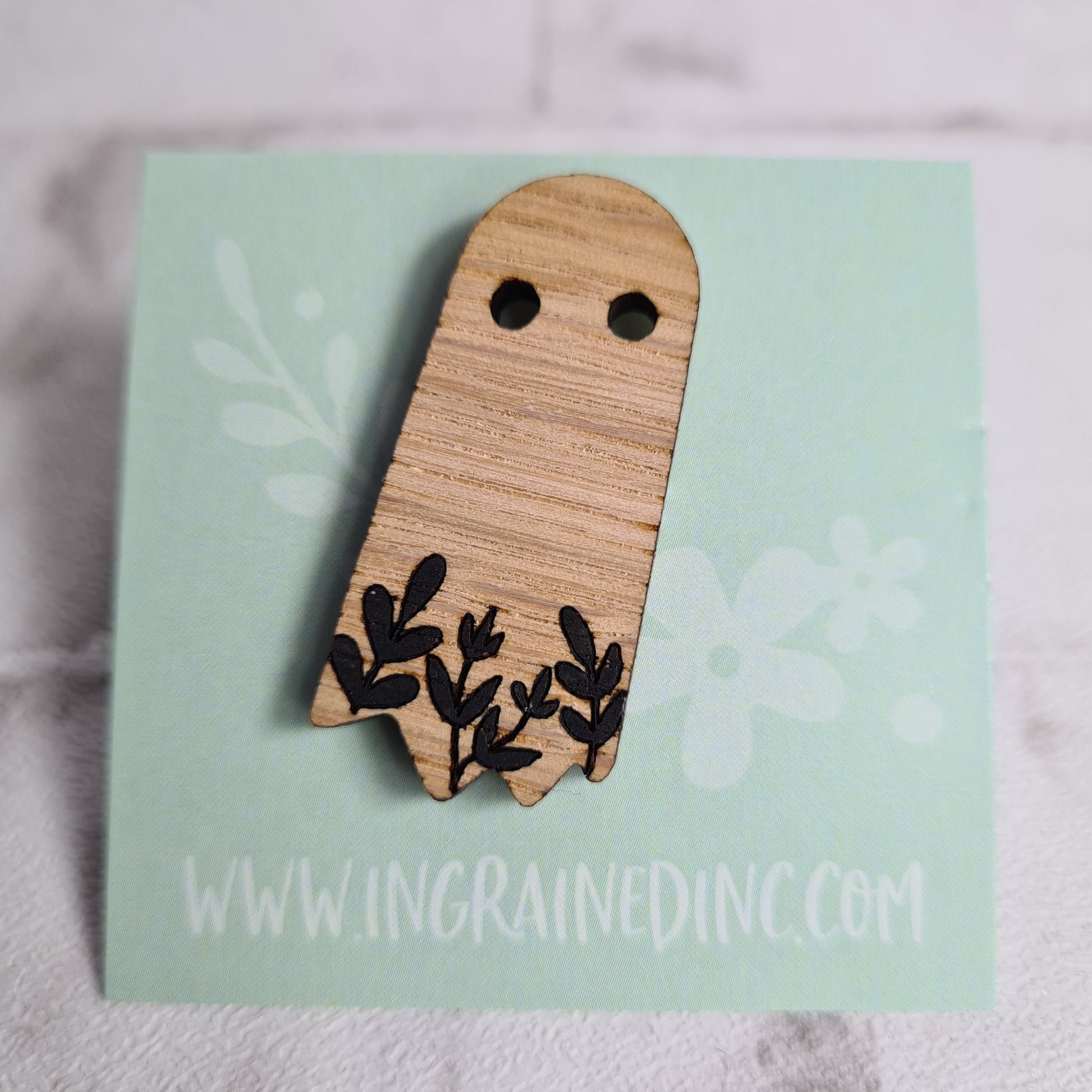 woodenspooky ghost pin brooch affixed to a backing card 