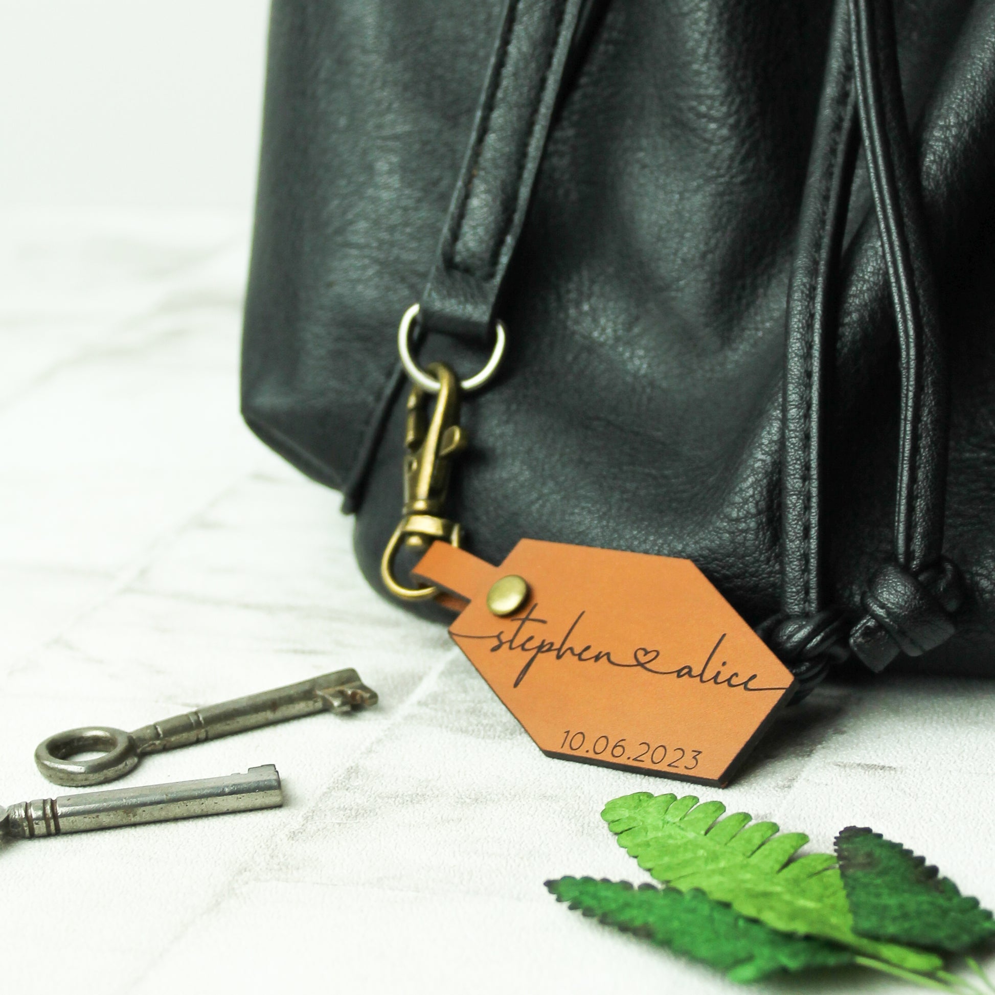 couple names and date engraved on a brown leather bag tag perfect for anniversary