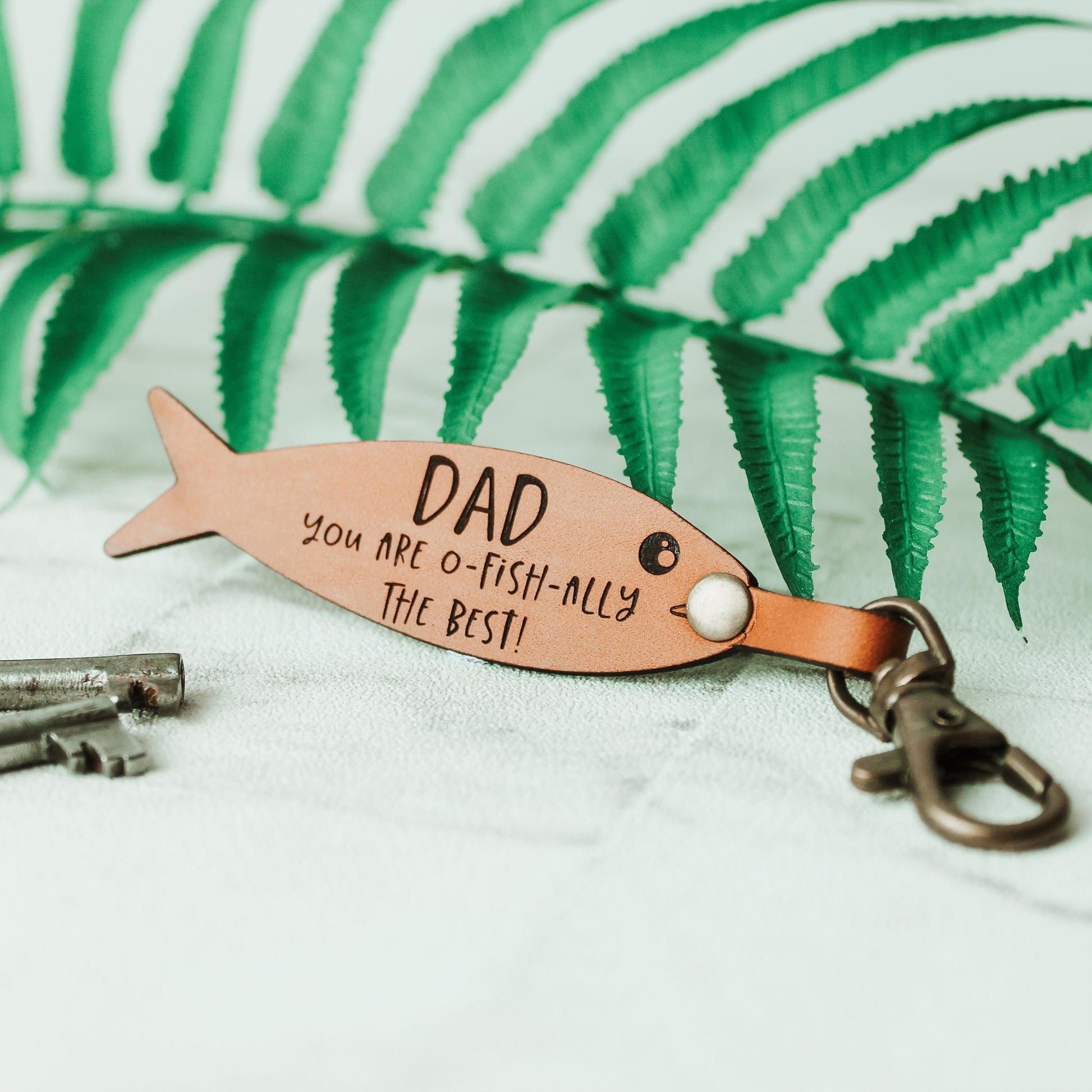 fish shaped keyring engraved with the words dad you are o fish ally the best made from leather