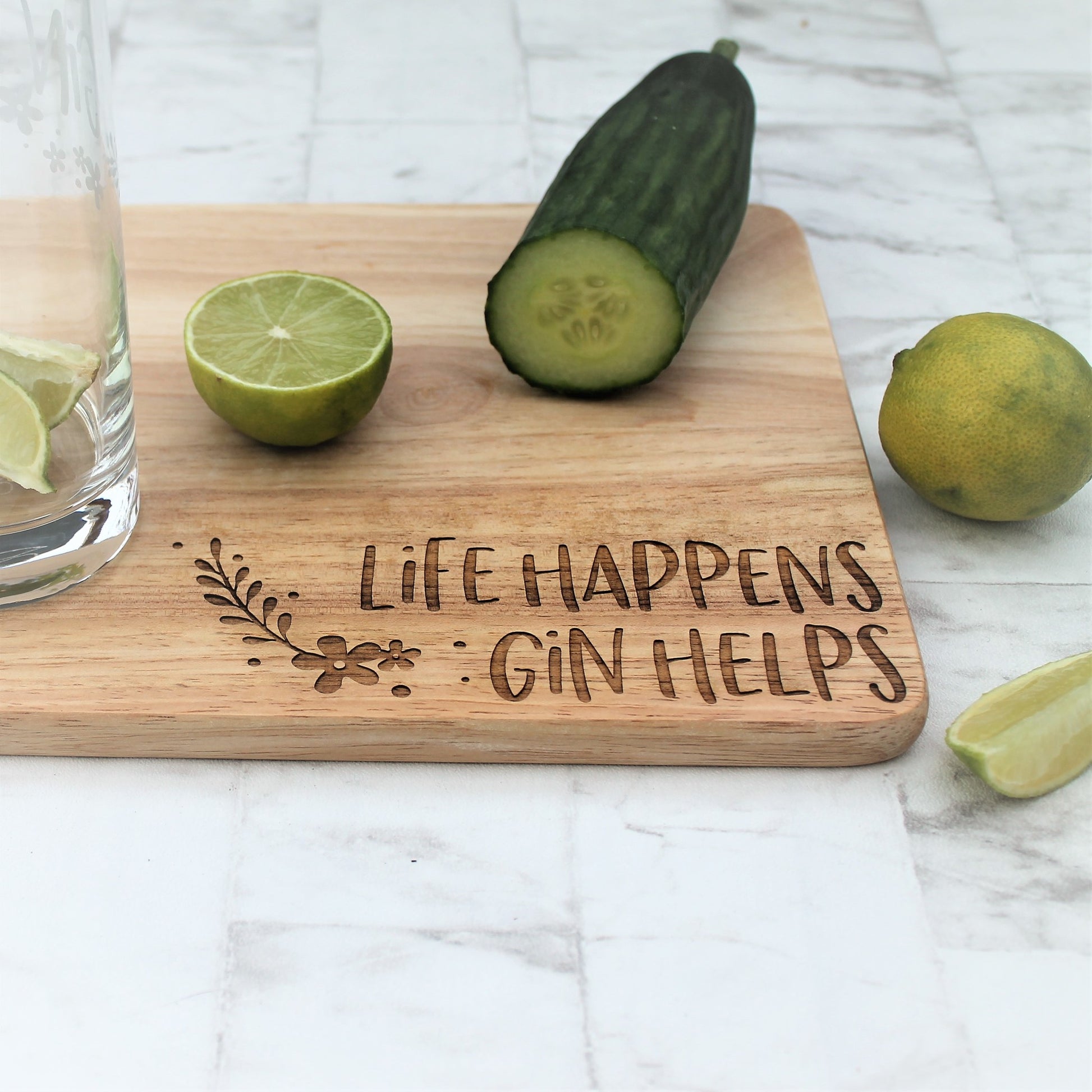 Wooden engraved gin chopping board with cucumbers and limes on top. Perfect gin gift