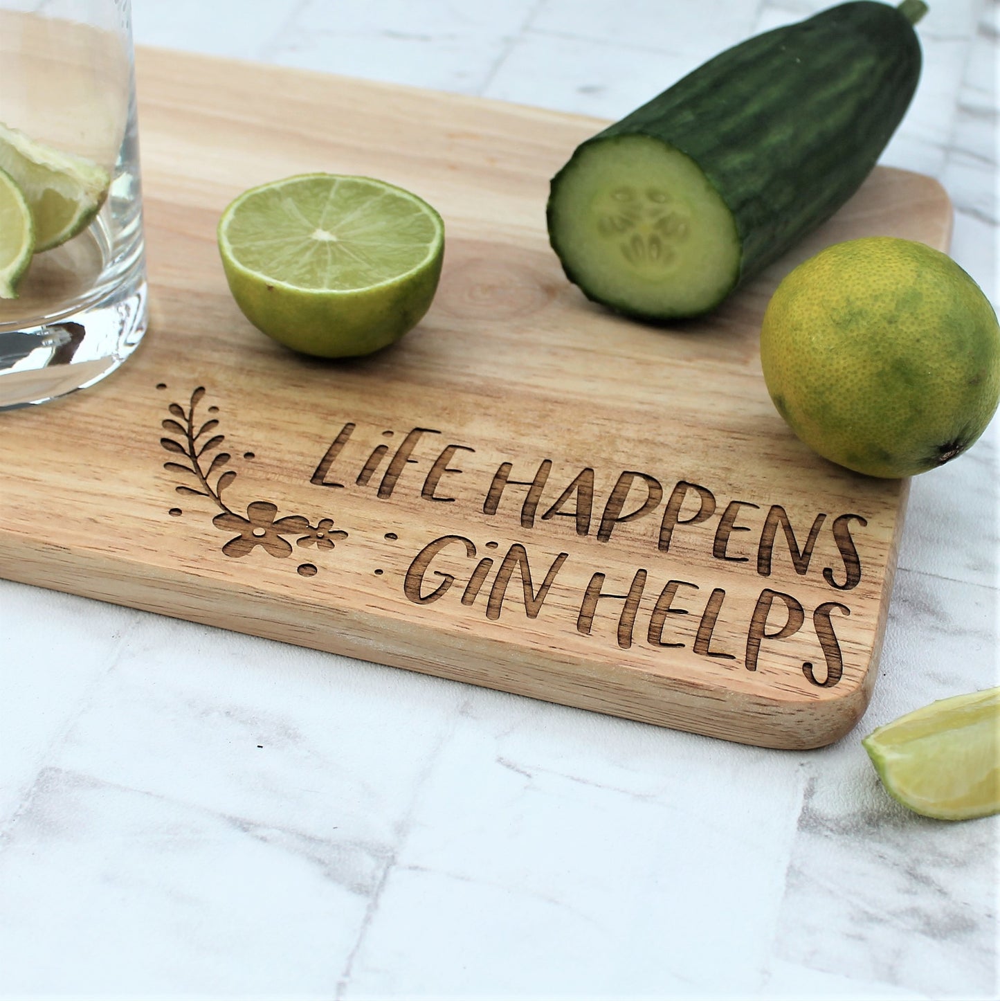 Wooden gin chopping board with the engraved words 'life happens Gin helps'