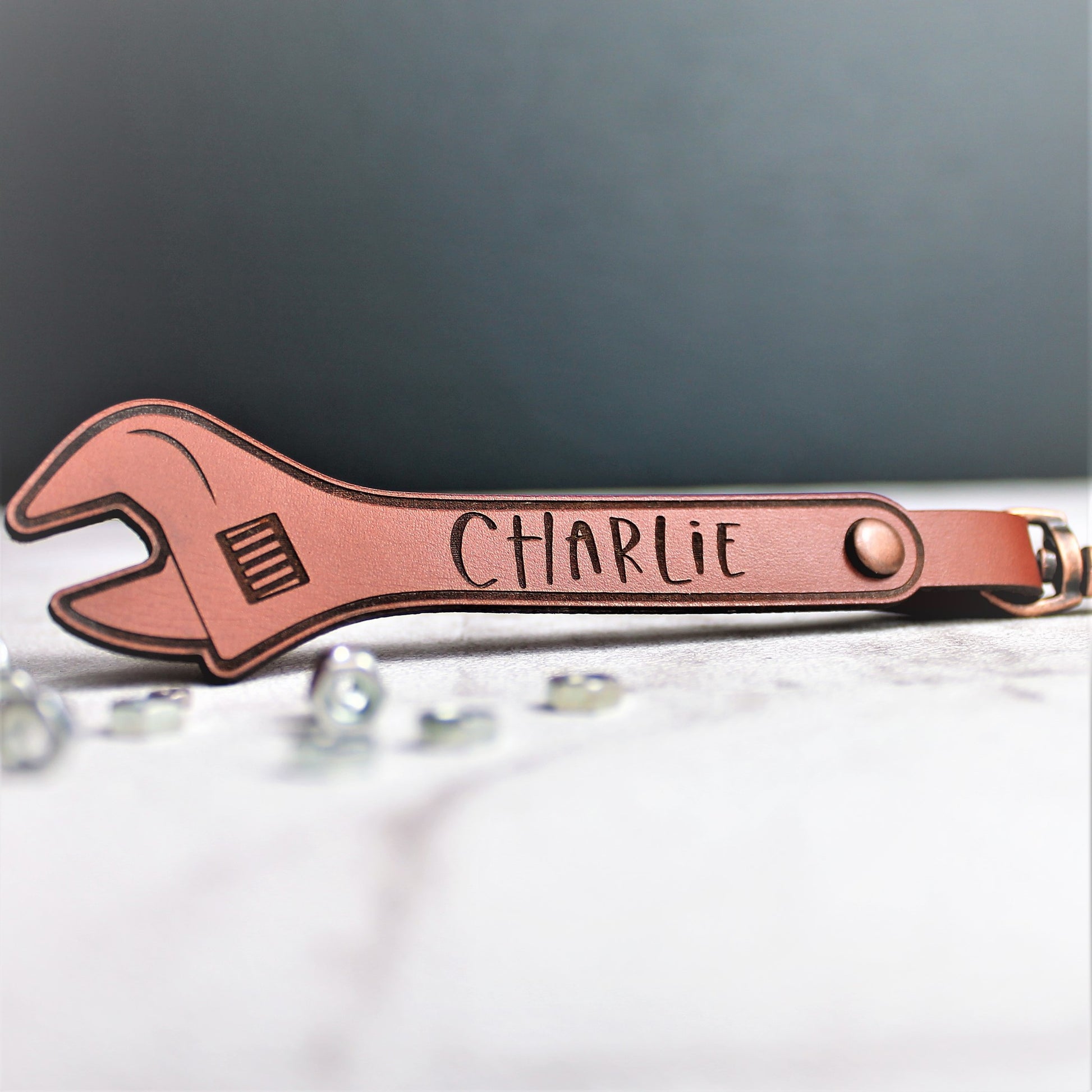 customised with a name leather keyring for him, in the shape of a spanner
