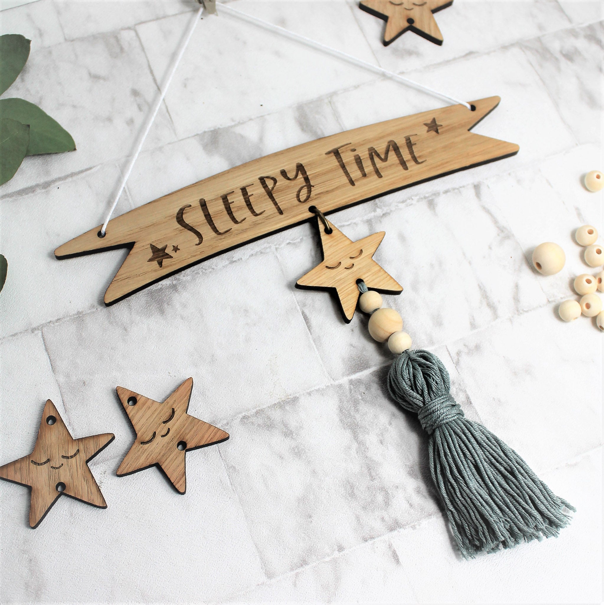 wooden banner style sign saying sleepy time with a sage colour tassel and sleeping star design
