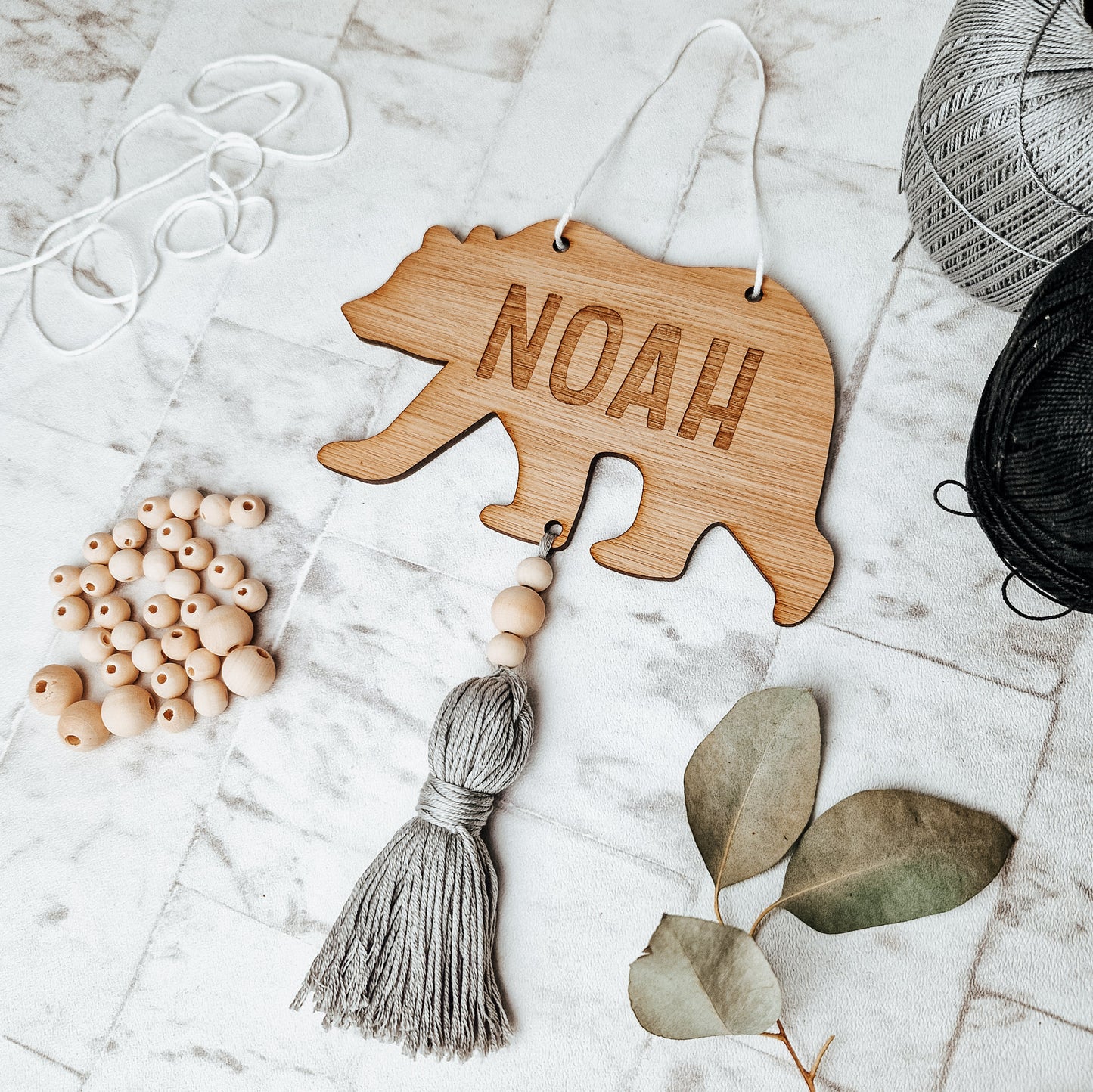 bear shape door sign made from wood, engraved with name or word of your choice. with affixed coloured tassel. Perfect for a woodland nursery 