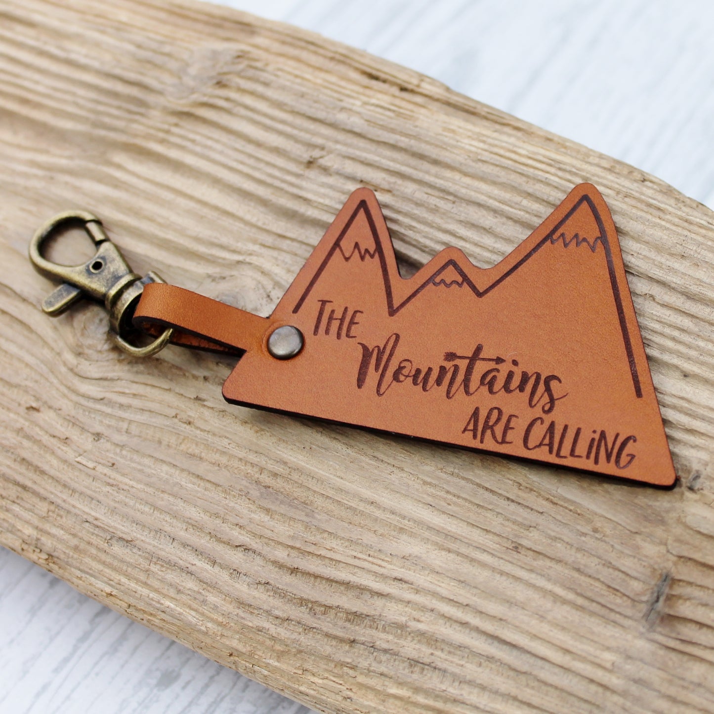 Brown leather keyring for adventurer with the quote engraved - the mountains are calling 